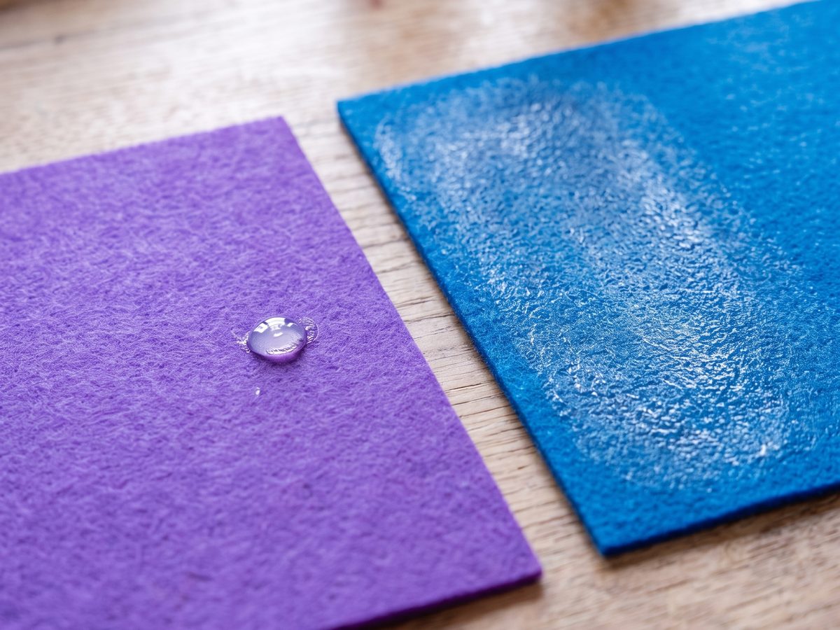 Klebstofftropfen auf lila Filz neben gleichmäßig besprühter Fläche auf blauem Filz